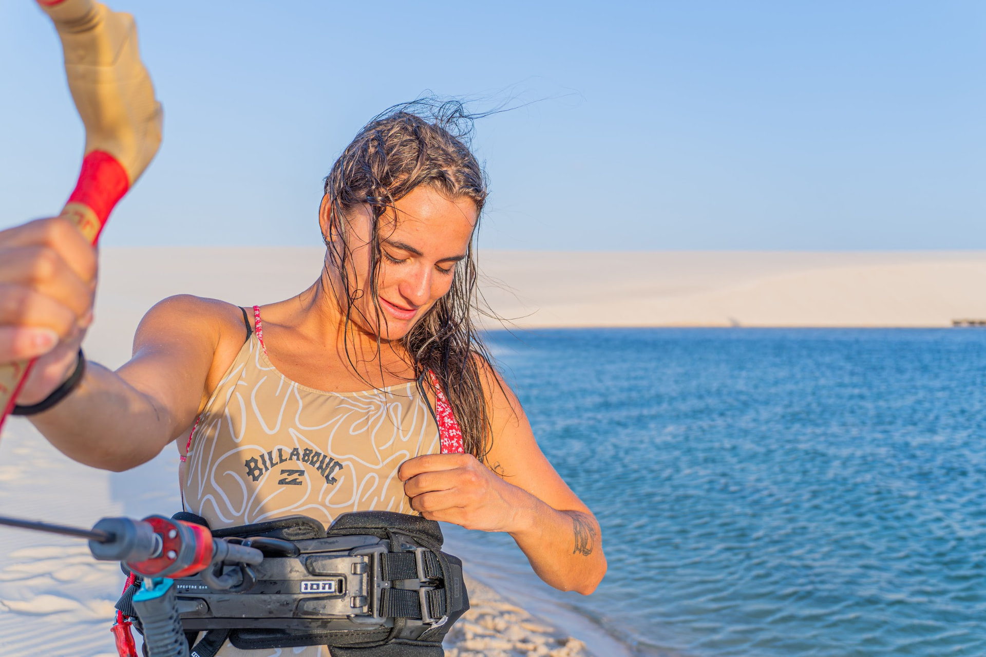 Gabi com traje Billabong na beira da lagoa