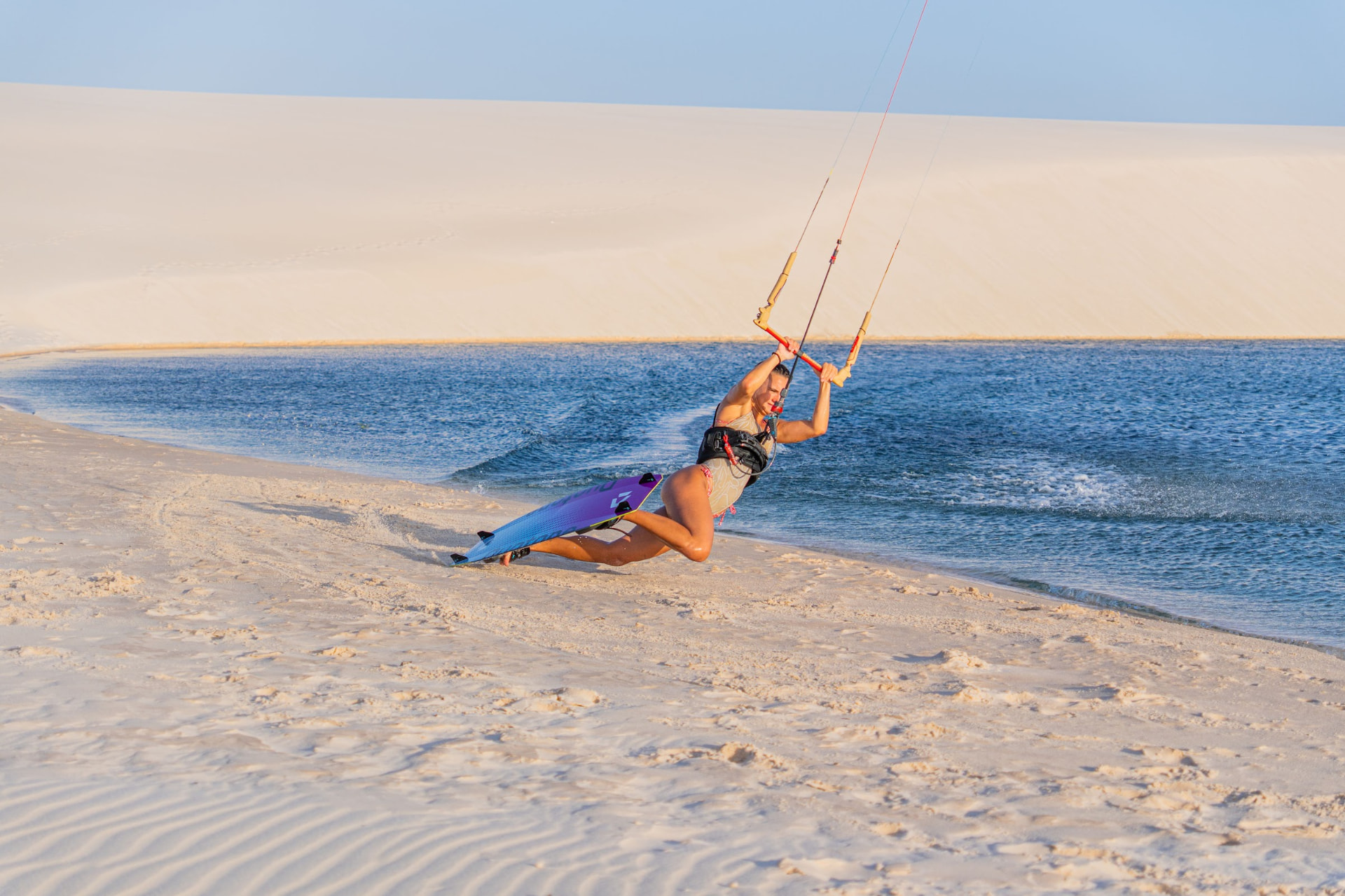Kitesurf rasgando a lagoa na beira da faixa de areia das dunas