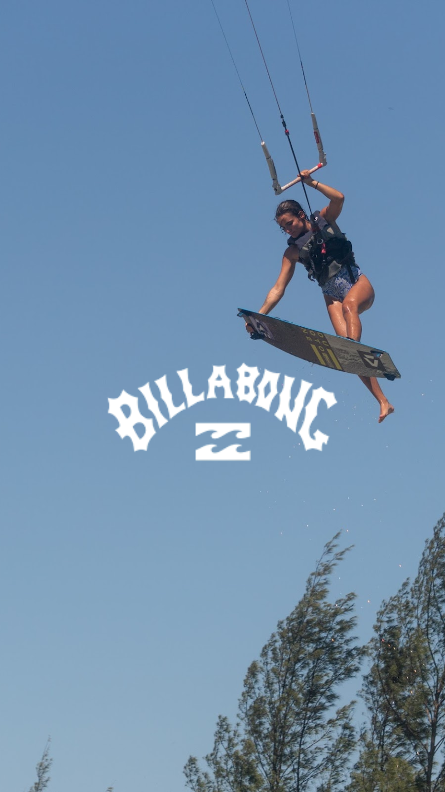 Gabi em manobra de kitesurf com o logo da Billabong