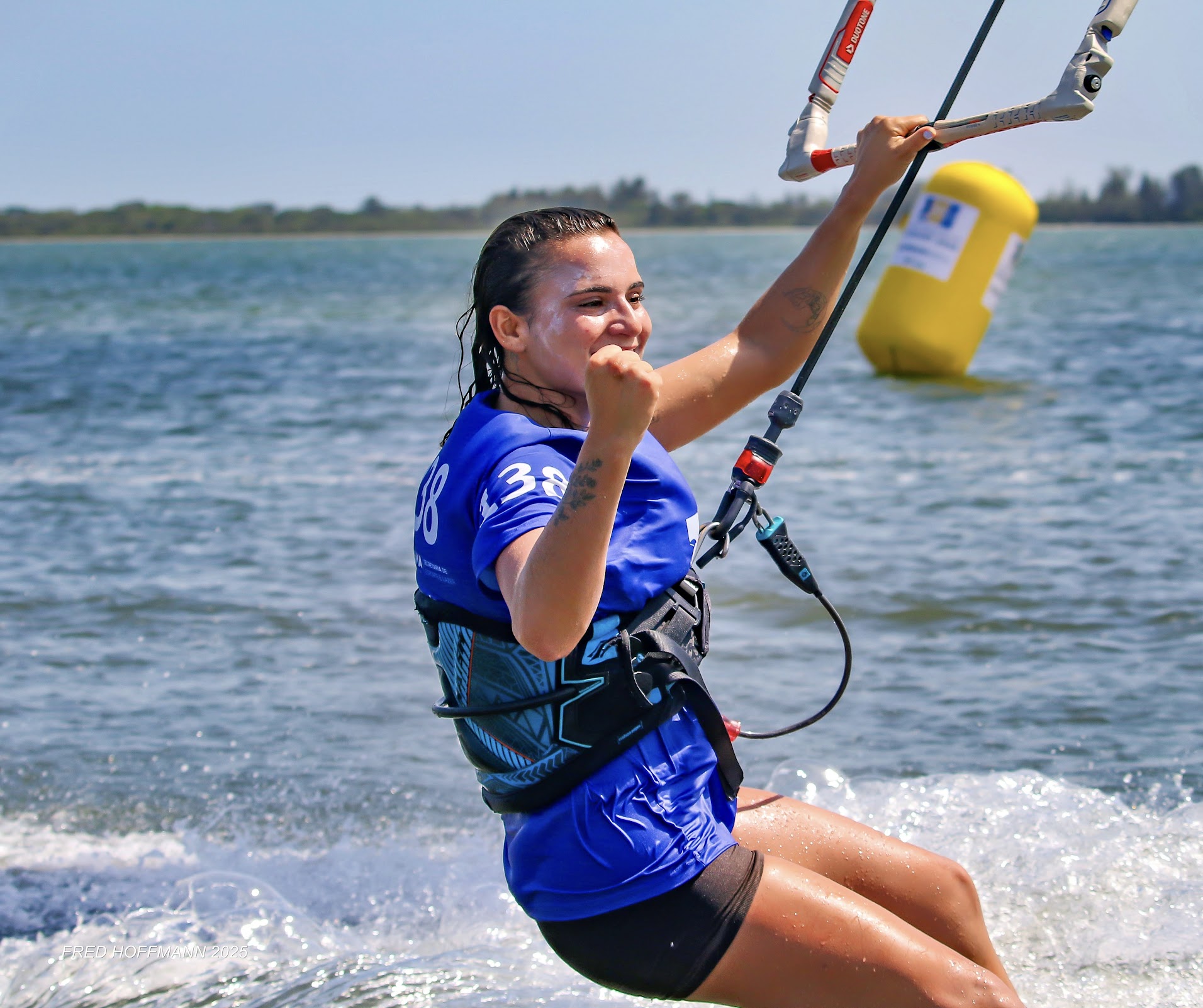 Gabi competindo de kitesurf com a lycra de prova