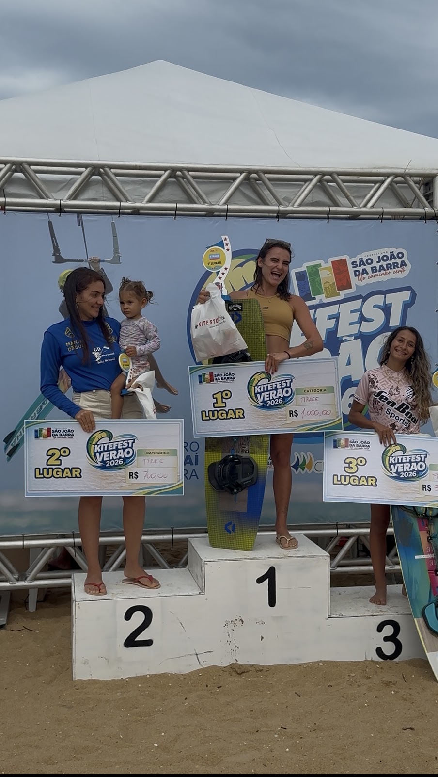 Gabi no pódio do Kitefest Verão 2026 com troféu de primeiro lugar